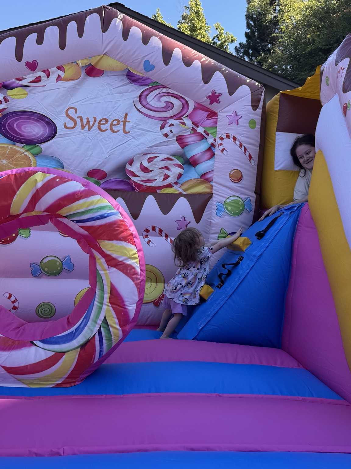 Children playing inside Candy Cloud beside the candy-themed wall and little climbing ramp